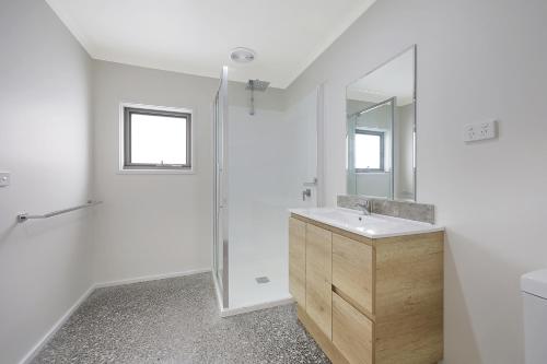 y baño blanco con lavabo y ducha. en Otway Coastal Villas, 1 Bedroom villa. en Princetown