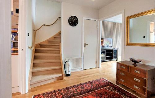 a room with a staircase with a clock on the wall at Awesome Home In Viken With Wifi And 2 Bedrooms in Viken