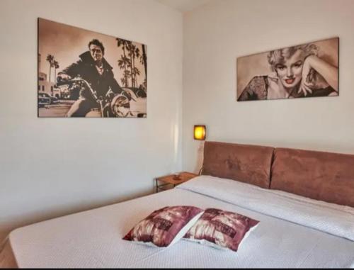 シルミオーネにあるResidence Orchideaのベッドルーム1室(壁に2枚の写真が飾られたベッド1台付)