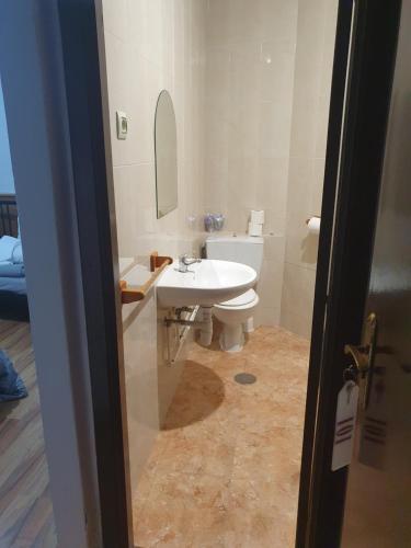a bathroom with a white sink and a toilet at A Concha in Lavacolla