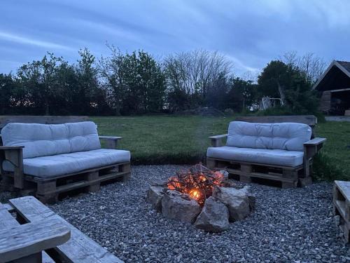 two couches and a fire pit in a yard at BG Apartments Safaritent in Somogyhatvan