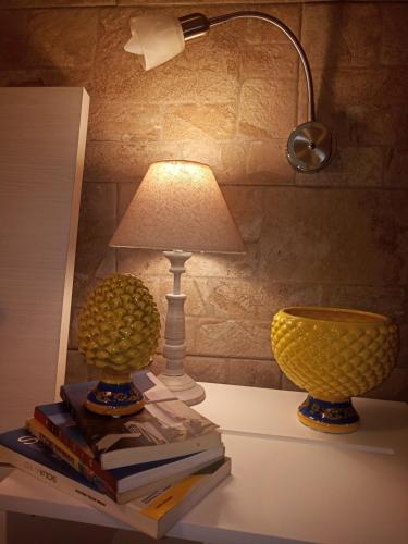 Deux lampes sur une table avec des livres et une lampe sur le dessus dans l'établissement Zisa Home ai Cantieri Culturali, à Palerme