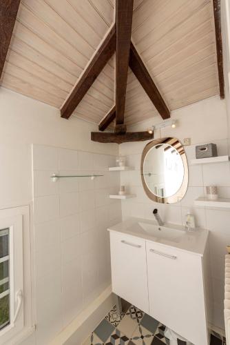 une salle de bain avec un lavabo blanc et un miroir dans l'établissement LE GITE du REFUGE du PEINTRE proche de St Emilion, à Sainte-Terre