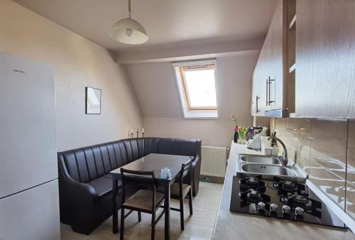 a kitchen with a table and chairs and a sink at Apartament in Timisoara in Timişoara
