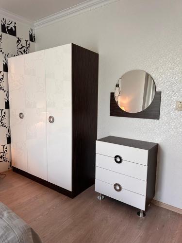 a bedroom with a white dresser and a mirror at PARKOVY apart in Truskavets