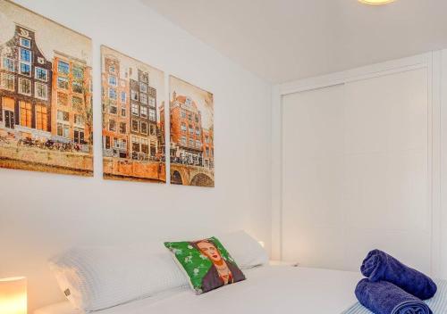 a bedroom with a white bed with a painting on the wall at Stylish flat and pool with 3 rooms, sleeps 6, Los cristianos in Los Cristianos