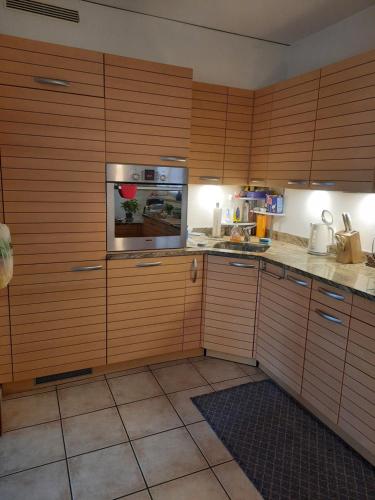 a kitchen with wooden cabinets and a stove top oven at Ampie camere con balcone giardino e piscina in Gordola