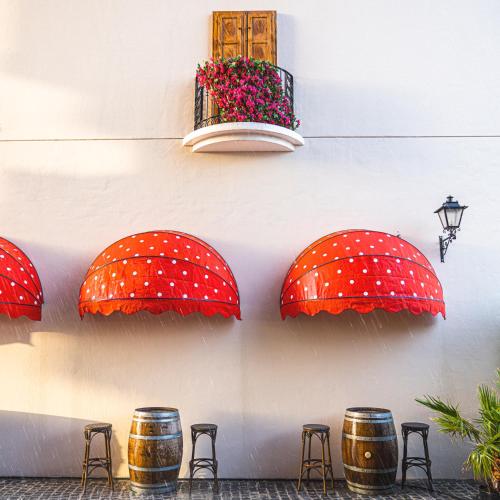 a group of red mushrooms on a wall with stools at voco Dubai Monaco, the Heart of Europe by IHG in Dubai