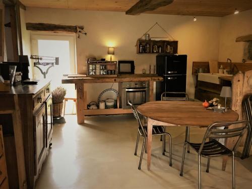 - une cuisine avec une table et des chaises dans la chambre dans l'établissement Suites de Campagne Les Eydieux, à Saint-Angel