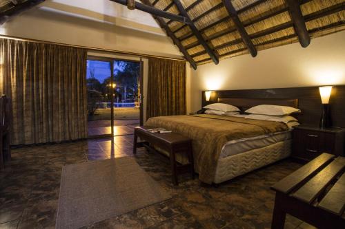 ein Schlafzimmer mit einem Bett und einem großen Fenster in der Unterkunft Sandy's Creations Resort in Lusaka