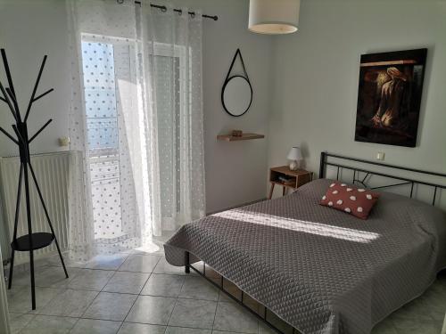 1 dormitorio con cama y ventana grande en Διαμέρισμα Παραλία Μενιδίου, en Menídion