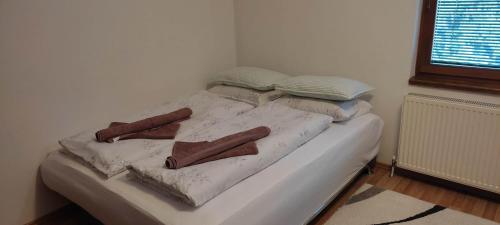 a white bed with blankets and pillows on it at Apartman Željo 1 in Livno