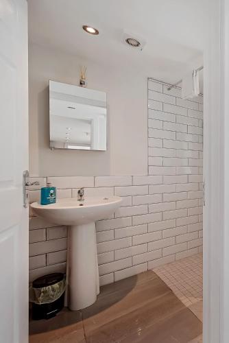 a white bathroom with a sink and a mirror at Carlisle Lodge 'Sleeping 6 guests' in Derry Londonderry