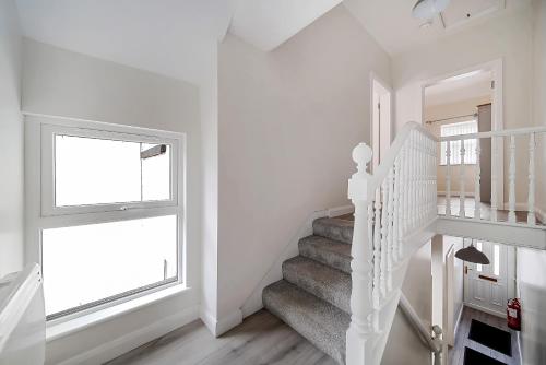 a white staircase in a white room with a window at Carlisle Lodge 'Sleeping 6 guests' in Derry Londonderry