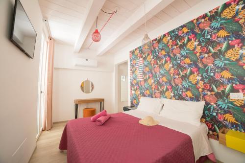 a bedroom with a pink bed with a colorful wall at retroscena matrimoniale in centro in Civitanova Marche