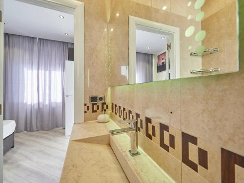 Unique Cozy Scenic Penthouse في برشلونة: حمام مع حوض ومرآة