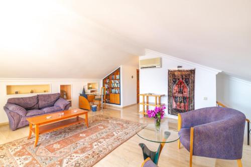 uma sala de estar com um sofá roxo e uma mesa em Korsan Apartment No.6 em Kas