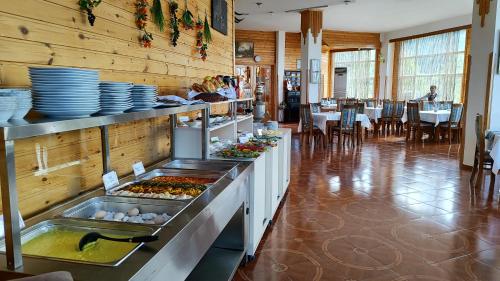 um restaurante com uma linha de buffet com pratos e comida em Kungut Hotel & Restaurant em Sheki