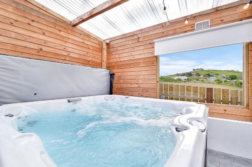 a bath tub in a room with a large window at Glenside Abbey 'Sleeping 7 guests' in Buncrana