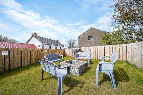 a group of chairs sitting around a fire pit in a yard at Glenside Abbey 'Sleeping 7 guests' in Buncrana