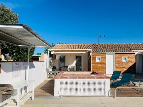 un patio con sillas, una mesa y una casa en Gite Blanco y Madera, en Narbona