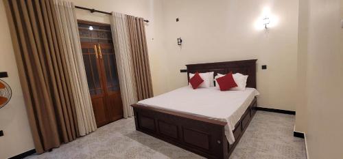 Un dormitorio con una cama con almohadas rojas. en CAW Dream Villa, en Ahangama