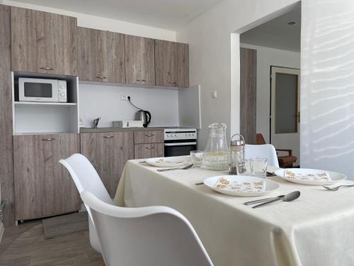 a white table with white chairs and a kitchen at Apartmány pri Zvonici in Oravský Podzámok