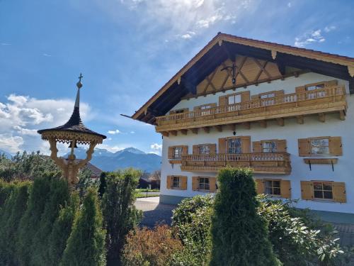 ein Gebäude mit einem Balkon und einem Pavillon in der Unterkunft Seeberghof in Frasdorf