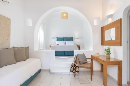 a white living room with a bed and a table at Elena Hotel Mykonos in Mýkonos City