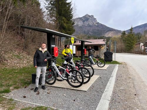 a man standing next to a bunch of bikes at a bus stop at Resort Drevenice Terchova in Terchová