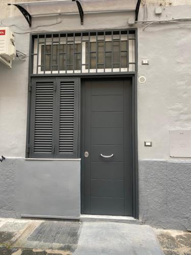 a garage with a black door on a building at House Casablanca in Naples