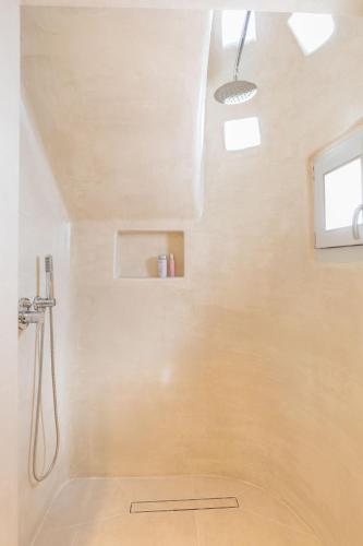 a white bathroom with a shower with a window at Elena Hotel Mykonos in Mýkonos City