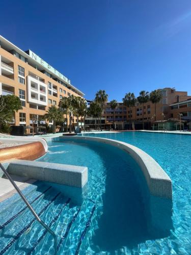 uma grande piscina em frente a um edifício em Hotel Neptuno by ON GROUP em Roquetas de Mar