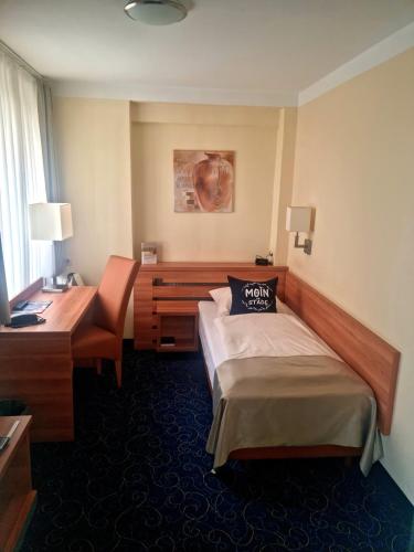 a hotel room with a bed and a desk at Kiek In Hotel Zur Einkehr in Stade