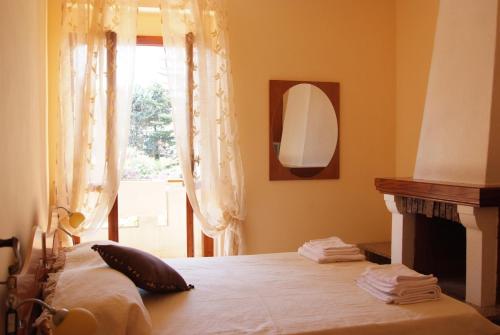 Hotel Barbieri في فيبو فالينتيا مارينا: غرفة نوم بسرير مع موقد ونافذة