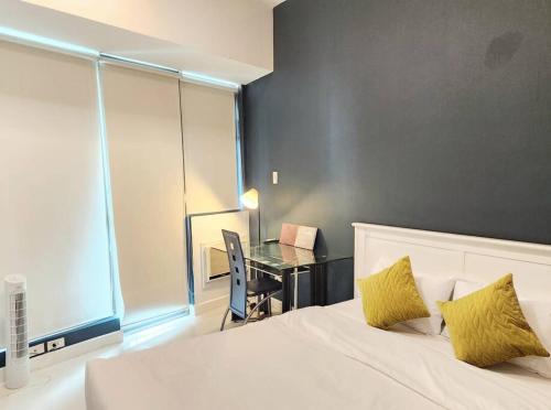 um quarto com uma cama, uma secretária e uma mesa em Nice and Cozy Studio near Greenbelt Makati with Balcony em Manila