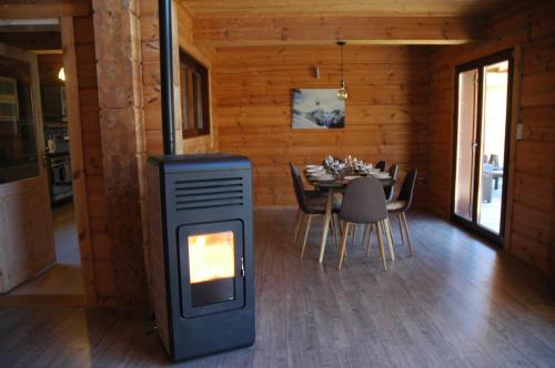 Cette chambre comprend un poêle à bois et une table à manger. dans l'établissement Chalet Etoile, à Abondance