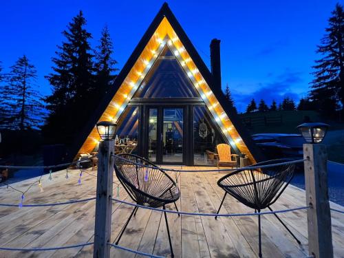 a house with lights on the front of it at La KOLTAU A-Frame in Mărişel