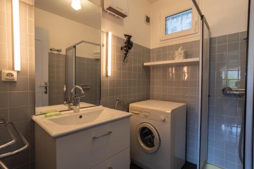 a bathroom with a sink and a washing machine at Vue sur les montagnes in Embrun