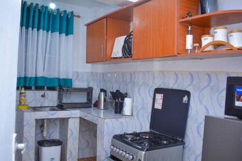 a kitchen with a stove and a counter top at Comfy, stylish, and family-friendly apartment in Karatina Town in Karatina