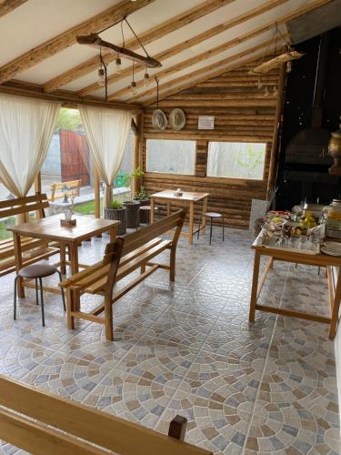 ein Zimmer mit Tischen und Bänken in einem Gebäude in der Unterkunft NOY Guest House B&B in Wanadsor