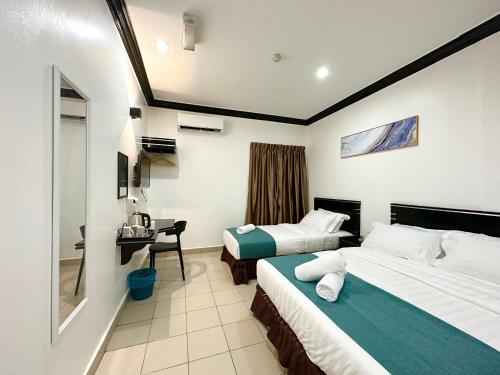 a hotel room with two beds and a desk at Hotel Tourist City Centre by HotSpot Essential in Kota Kinabalu