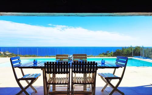 una mesa y sillas con vistas al océano en Villa Crystal River, piscine privée & vue mer sur Golfe de Saint Tropez, en Saint-Peïre-sur-Mer