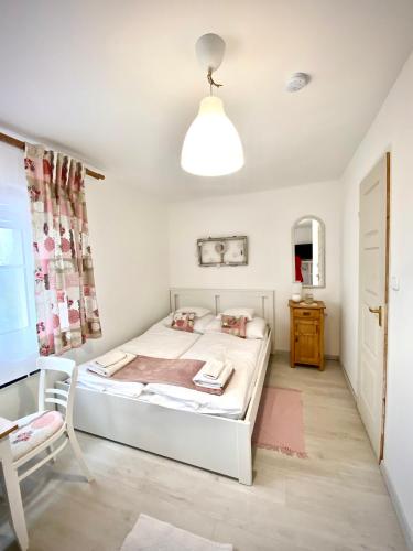 a bedroom with a bed and a table and a chair at BorászPorta - Présház in Villány