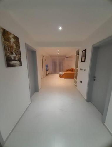 a white hallway with a living room and a couch at Jan-Air in Ilinden