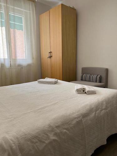 a bedroom with a large white bed and a cabinet at Best Way Rent - Casa Ida in Lavagna