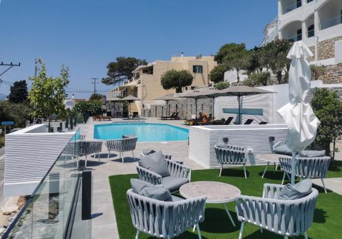 a patio with chairs and a table and a pool at Anthemis Hotel Apartments in Samos