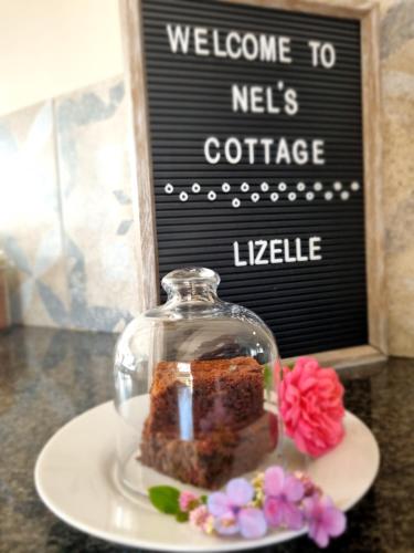 a piece of cake in a glass dome on a plate at Nel's Cottage, a private and peaceful cottage in Benoni