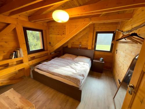 1 dormitorio con 1 cama en una cabaña de madera en Chata Křivoklát, en Křivoklát