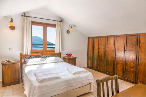 a bedroom with a bed with wooden cabinets and a window at Korsan Apartment No.12 in Kaş